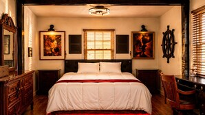 A bedroom with a large bed, wooden floor, a desk, a chair, and two wall-mounted lamps. - Historic Family Escape Near Downtown, Romantic + Pet-Friendly (Wilmington)
