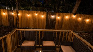 An outdoor deck with wicker furniture and string lights. - Historic Family Escape Near Downtown, Romantic + Pet-Friendly (Wilmington)