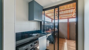 A compact kitchen with a built-in dishwasher, a microwave, and a sink.