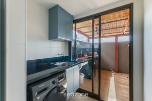 Uma cozinha compacta com lava-louças embutida, micro-ondas e pia.