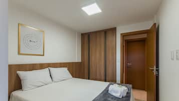 Habitación de hotel con cama, armario de madera, una puerta y una cita enmarcada en la pared.
