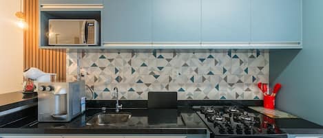 Een moderne keuken met een magnetron, broodrooster en spoelbak.