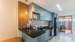 A modern kitchen with a central island, a microwave, a stove, and a refrigerator.