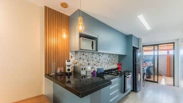 Une cuisine moderne dotée d’un îlot central, d’un four à micro-ondes, d’une cuisinière et d’un réfrigérateur.