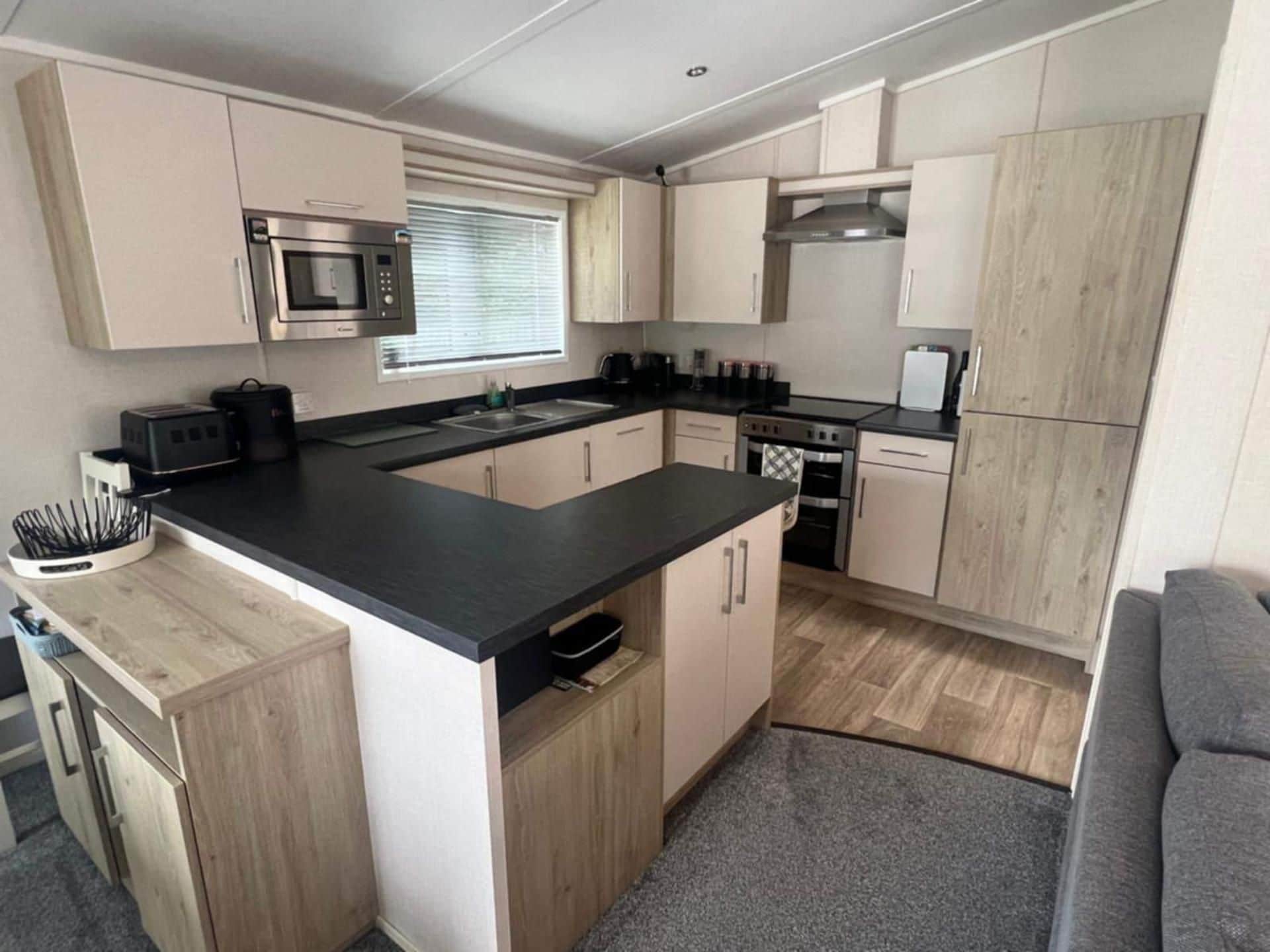A compact kitchen with a central island, built-in microwave, and a stove.