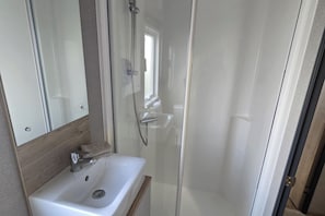 Chuveiro, secador de cabelo, papel higiênico 