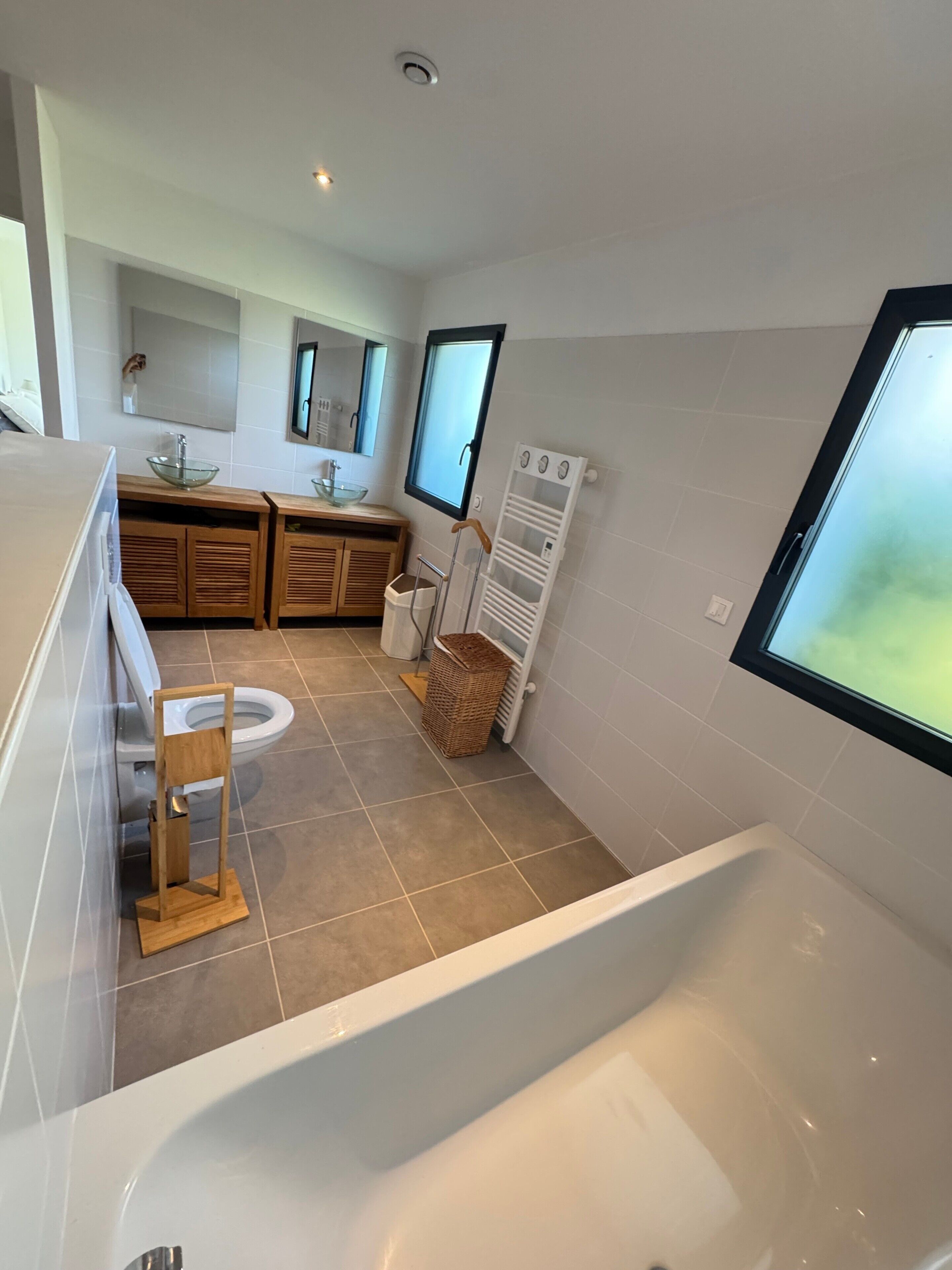 A modern bathroom with a bathtub, toilet, and sink.
