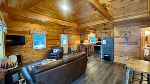 A log cabin interior with a living room, kitchen, and dining area. - Moosehead State of Mind, 3BR Cabin with Mtn Views & Deck (Shirley)