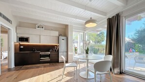 A modern kitchen with a dining area, wooden flooring, and large windows. - Holiday Home 'Villa Traimari' with Sea View, Wi-Fi and Air Conditioning (Trani)