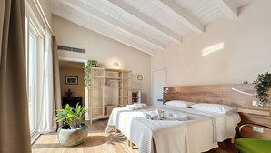A modern bedroom with two beds, a wooden headboard, a green chair, and a large potted plant. - Holiday Home 'Villa Traimari' with Sea View, Wi-Fi and Air Conditioning (Trani)