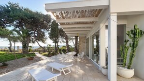 A patio with white furniture, a pergola, and potted plants. - Holiday Home 'Villa Traimari' with Sea View, Wi-Fi and Air Conditioning (Trani)