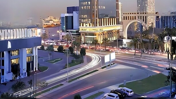 A modern urban intersection with high-rise buildings, a roundabout, and a clear sky. - Sedra Global Hotel Jeddah (Jeddah)