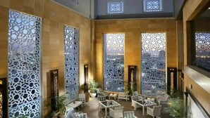 An indoor courtyard with seating, decorative screens, and a view of the city. - Sedra Global Hotel Jeddah (Jeddah)