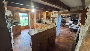 Une cuisine rustique avec des meubles en bois, un mur recouvert de carreaux et un mur en pierre.