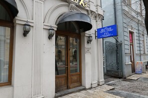 Un bâtiment doté d’une grande entrée en arc de cercle, d’une enseigne et d’un portail en métal.