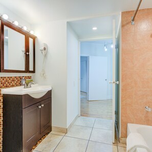 A bathroom with a vanity, mirror, and a shower area. - 303 N 3rd St B2 (Philadelphia)