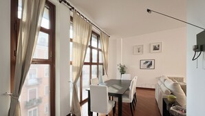 Ein Essbereich mit Tisch, Stühlen, einer Couch und einer Heizung.