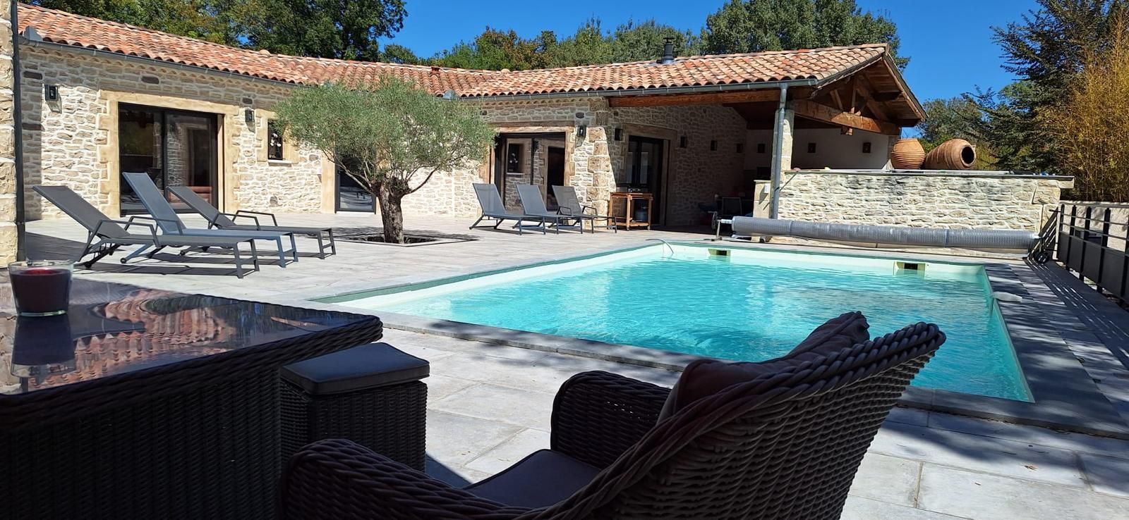 Une villa en pierre dotée d’une piscine, d’un espace extérieur aménagé et offrant une vue sur le paysage environnant.