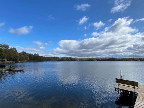 A calm lake with a wooden dock and a sign indicating a picnic area. - Long Lake Waterfront Cabin: Family Fun (Longville)