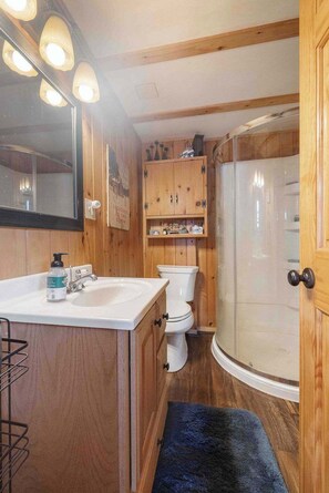 Une petite salle de bain comprenant un lavabo, des toilettes et une douche.