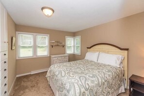 A bedroom with a bed, dresser, nightstand, and two windows with blinds. - Upper Hay Pet Friendly Getaway Home (Pequot Lakes)