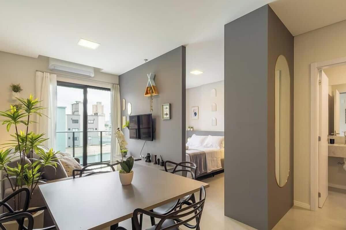 Een moderne hotelkamer met een eethoek, een televisie en uitzicht op de stad.