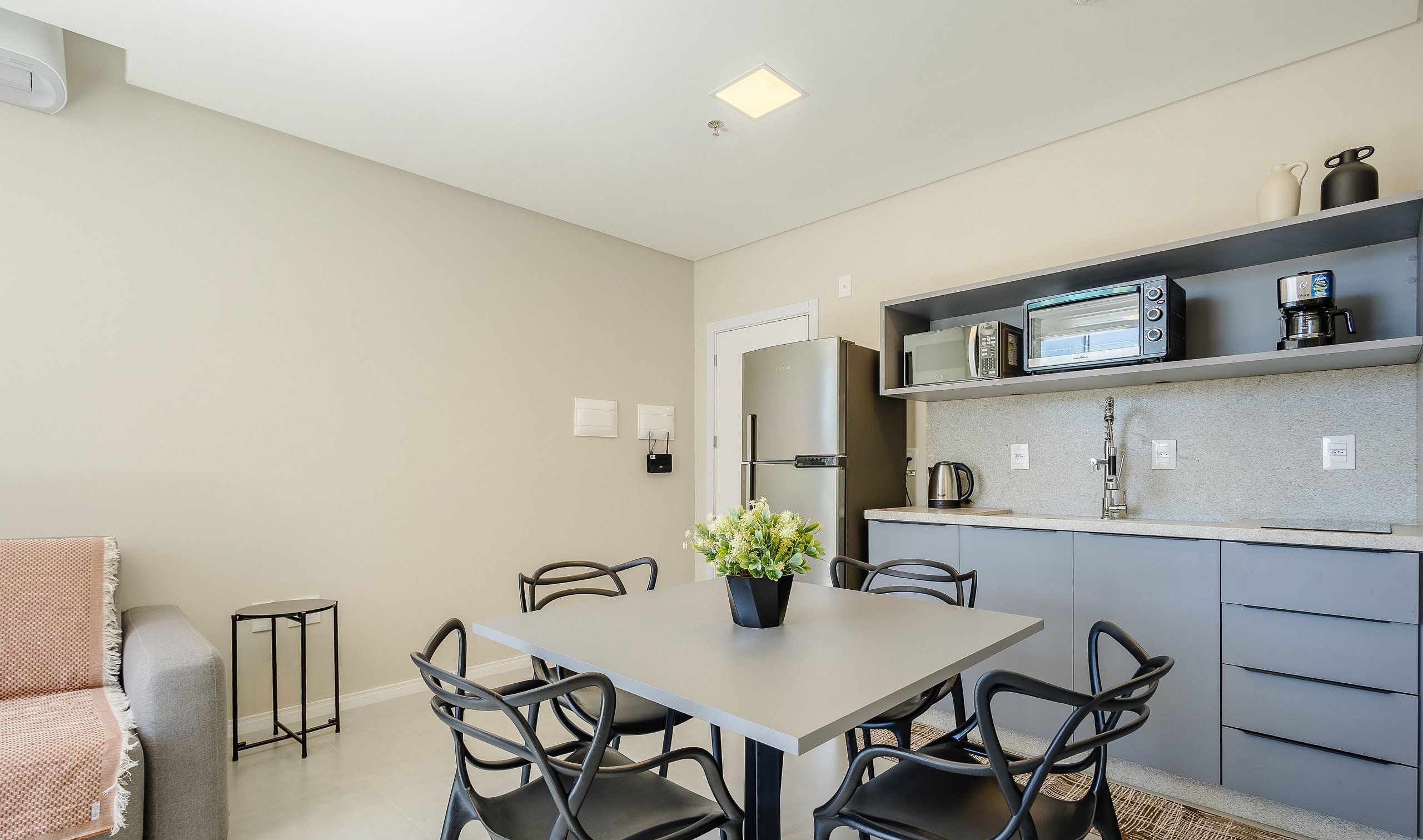 A compact kitchen with a refrigerator, microwave, and coffee maker on the countertop.