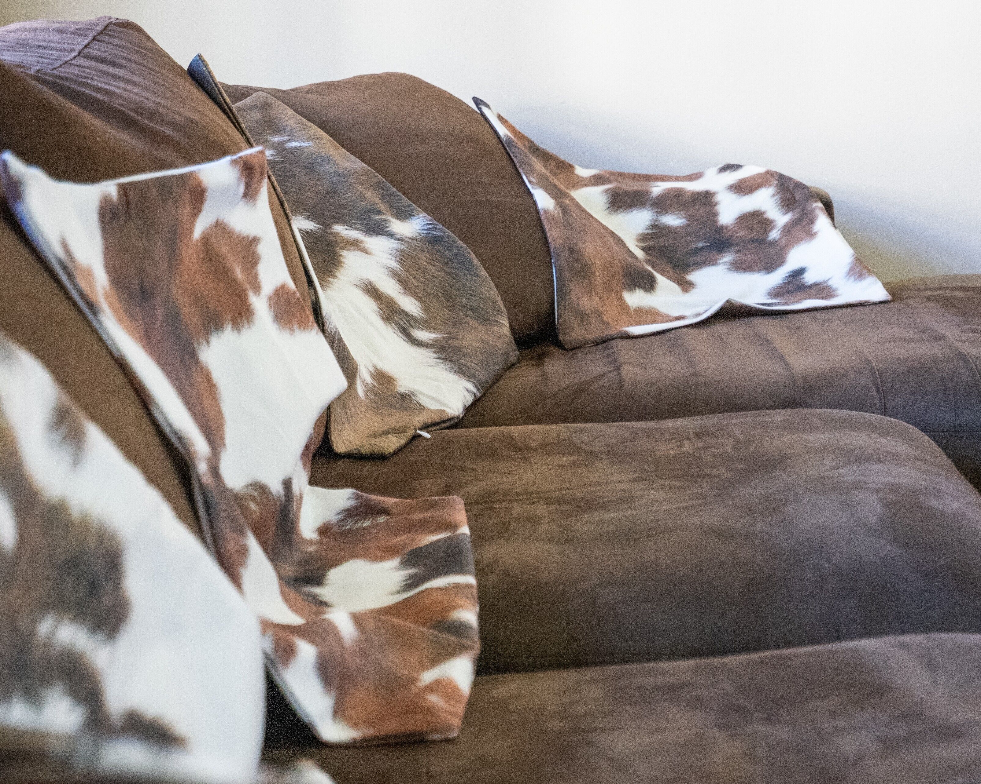 A brown sofa with a patterned throw blanket.