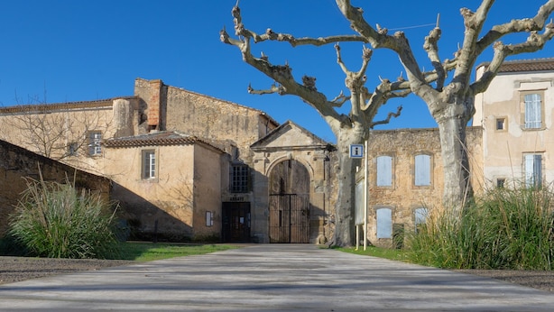 A courtyard with a building labeled 'Abbaye,' a tree, and a paved area with a relief sculpture.