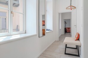 A hallway with a bench, a mirror, and a hanging light fixture. - Parking / Old Town / Balcony - Palais Orange (Meißen)