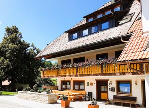 A traditional building with a balcony, outdoor seating, and a stone wall. - Apartment Kirchblick with Balcony and Wi-Fi (Horben)