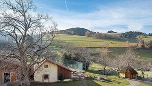 A rural landscape with a small wooden house, a paved path, and a grassy area. - Apartment Wiesenblick with Balcony and Wi-Fi (Horben)