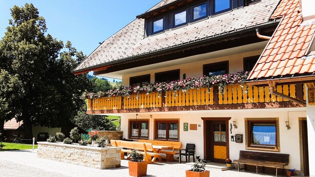 A traditional building with a balcony, outdoor seating, and a stone wall. - Apartment Talblick with Balcony and Wi-Fi (Horben)
