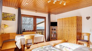 A cozy room with a bed, a desk, a chair, a bookshelf, and a TV. - Double Room Apartment with Balcony and Wi-Fi (Horben)