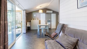 A modern interior with a sofa, dining table, chairs, and an air conditioning unit.