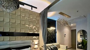Un dormitorio moderno con una cama grande, un sofá, una mesita de centro y vistas al cielo nocturno a través de una ventana.