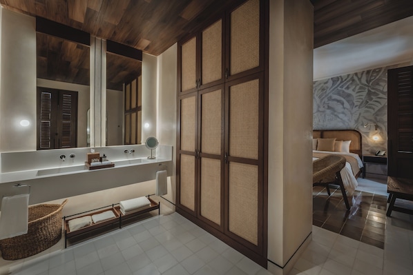 A modern bathroom with a large mirror, wooden paneling, a bathtub, and a wicker basket. - Del Alma Merida (Mérida)