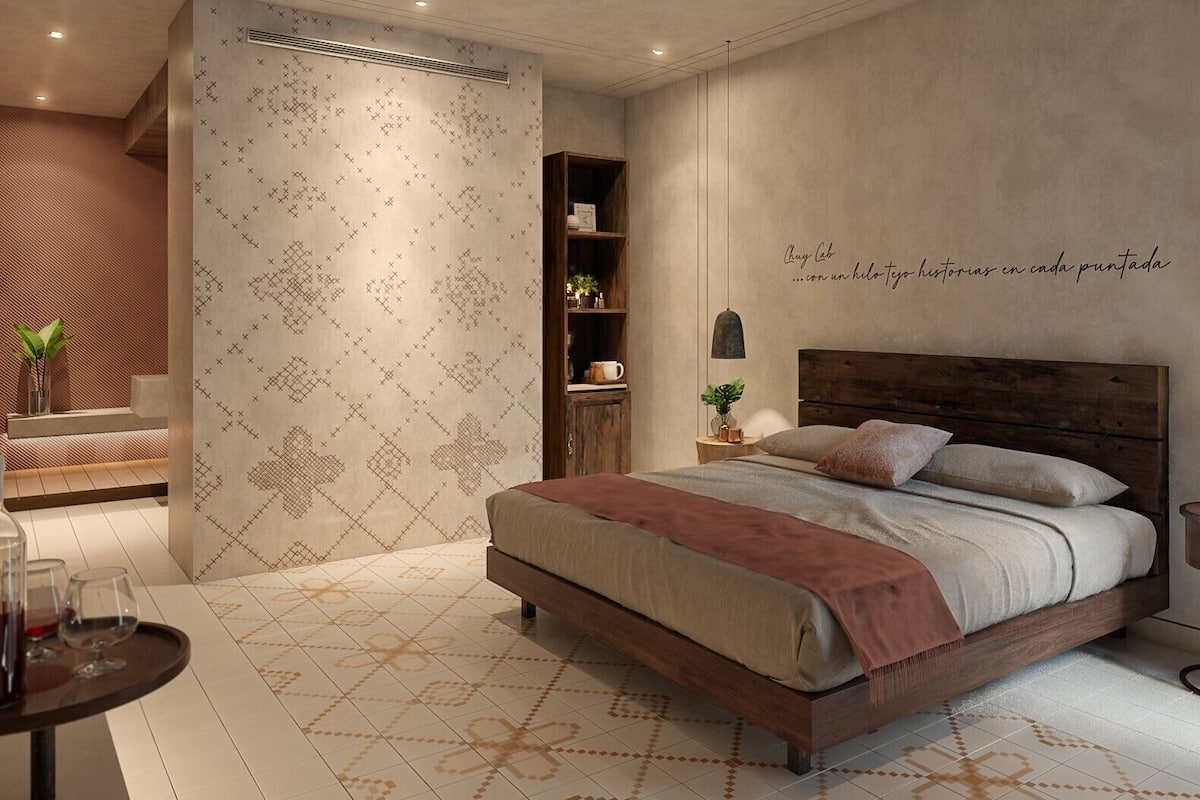 A modern bedroom with a large bed, a small side table, a bookshelf, and a decorative wall with a quote.