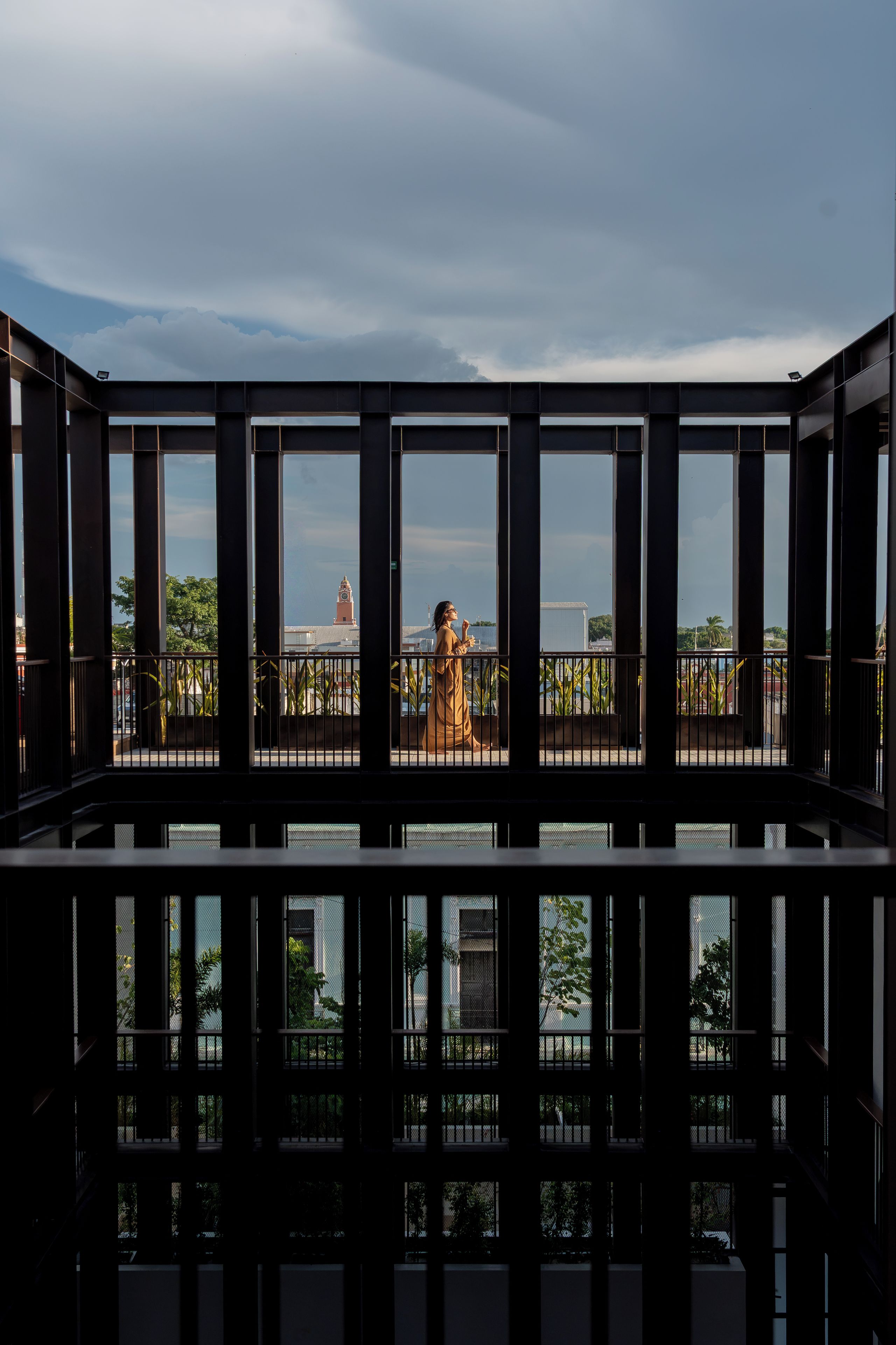A room with a view of a cityscape through a window with a metal frame.