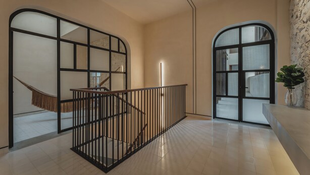 A modern interior with a staircase, glass partitions, and a plant. - Del Alma Merida (Mérida)