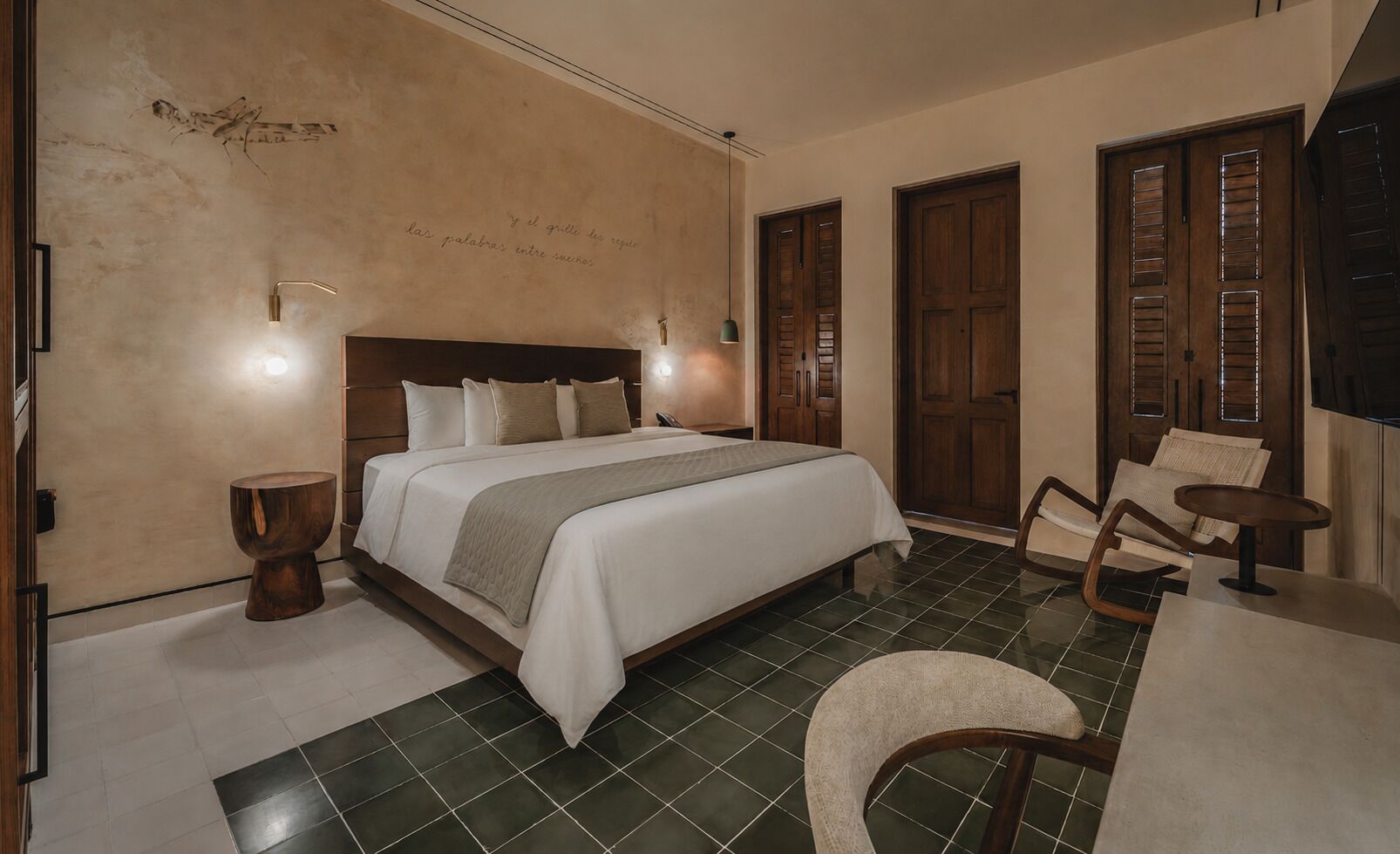 A bedroom with a bed, bedside tables, a chair, and a desk.