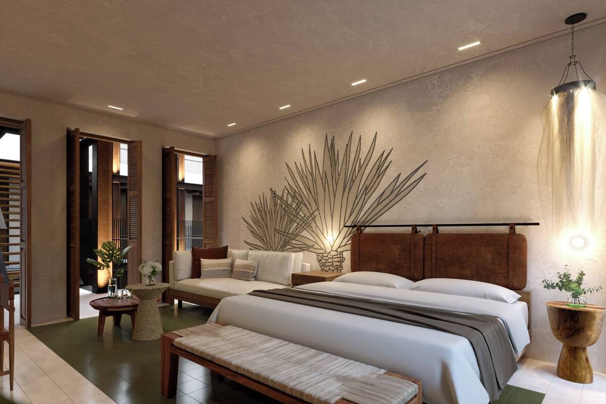 A modern bedroom with a large bed, a bench, a sofa, and a wall art piece.