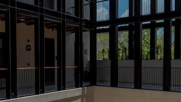 A multi-level atrium with open balconies, a central courtyard with seating, and a large potted plant.