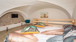 Una camera da letto con soffitto a volta, una struttura letto in legno e un'ampia finestra.