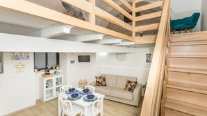 Un interno moderno con zona pranzo, divano e scala.