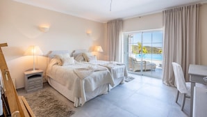 A bedroom with two beds, a desk, a chair, and a view of the outdoors. - Bedroom in a Villa, Budens (Vila do Bispo)