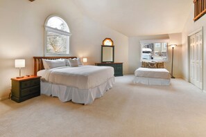 A bedroom with a large bed, a nightstand, a dresser, a mirror, and a window. - Walk to Main Street & Ski Access (Park City)