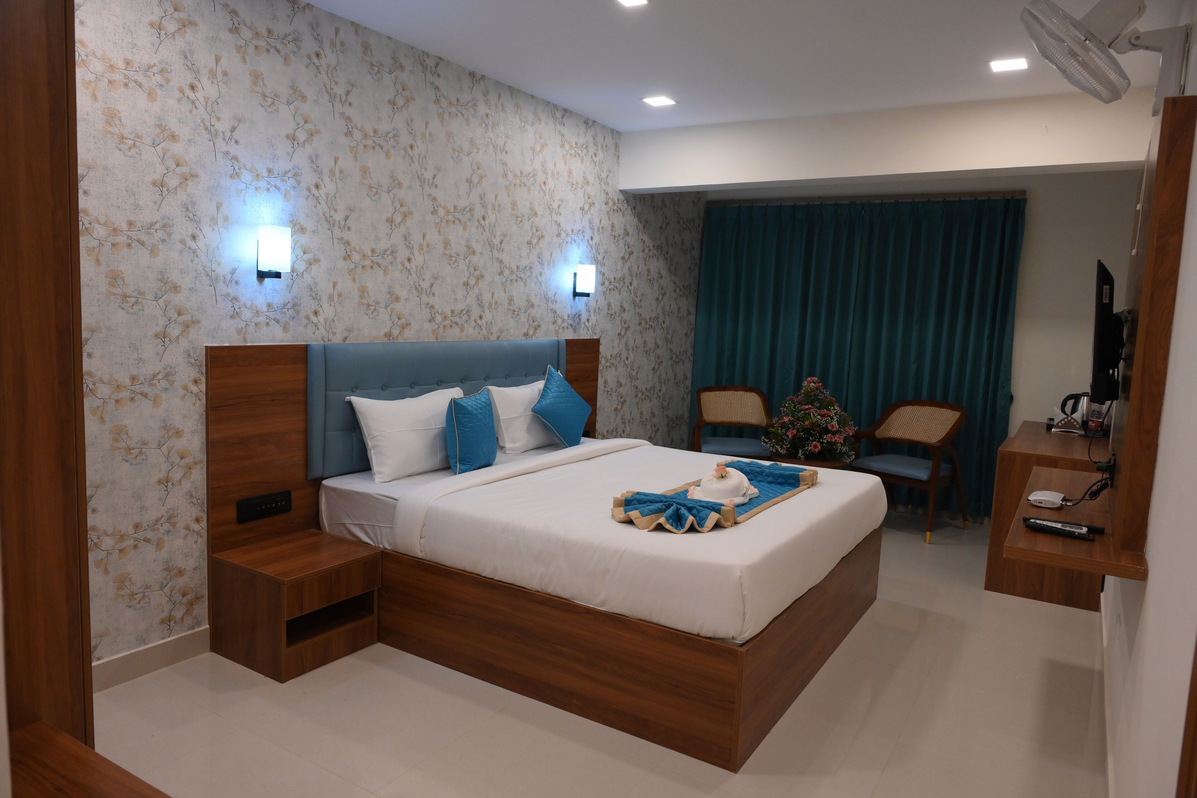 A modern bedroom with a wooden bed, bedside tables, a desk, and a chair.