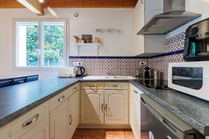 Una cocina con horno empotrado, microondas y lavaplatos.