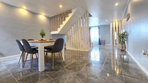 A spacious dining area with a modern staircase, a polished tile floor, and a minimalist design. - Casa da Maré Azul (São Roque)